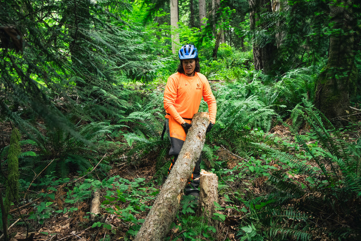mountain biker moving a tree log out of the path