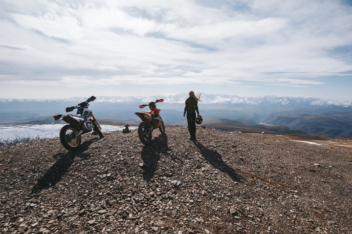 dirt biker enjoys a summit view while riding