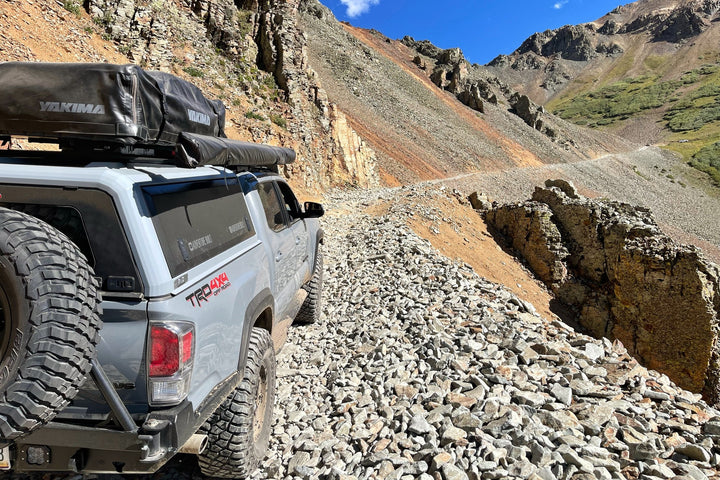 an overlanding rig on a narrow, rocky mountain road